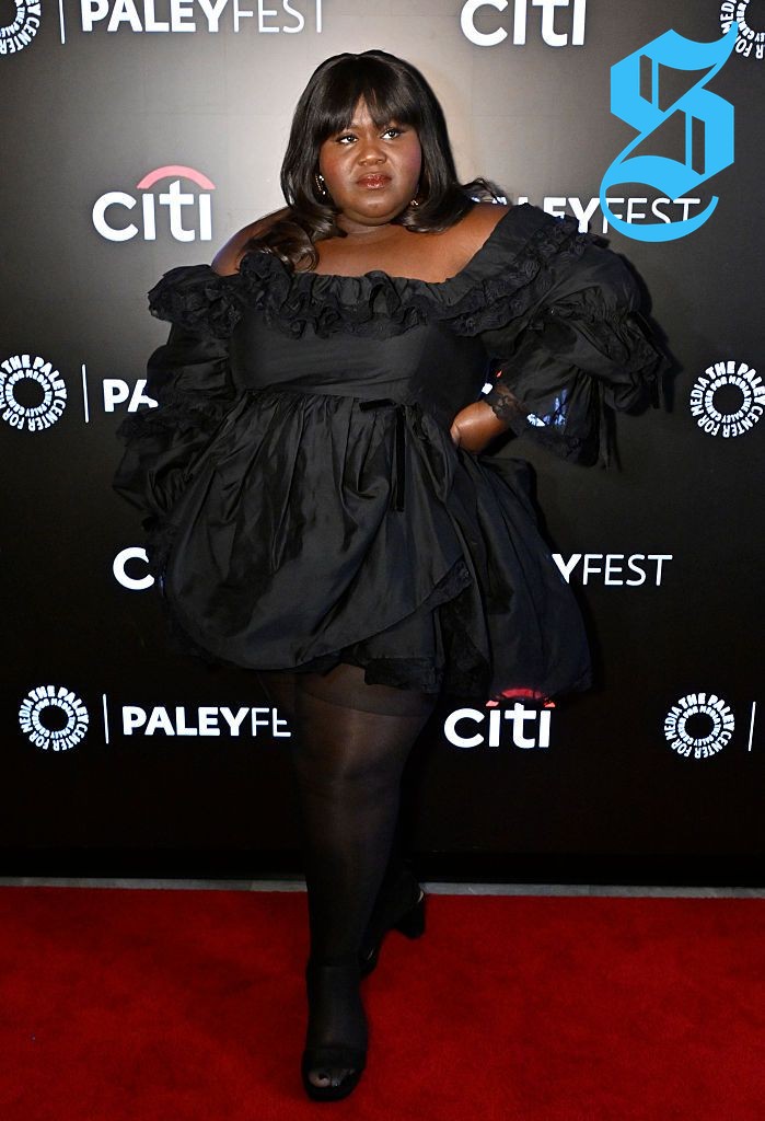 Gabourey showcasing a stylish little black dress with oversized sleeves.